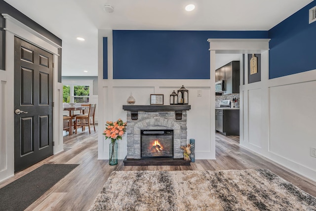 6 Premier Ct, Port Jefferson Station, NY 11776 - living area featuring a decorative wall, visible vents, a stone fireplace, and wood finished floors
