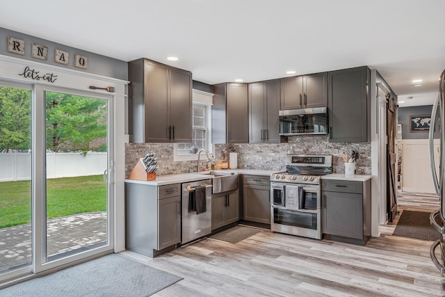6 Premier Ct, Port Jefferson Station, NY 11776 - kitchen with tasteful backsplash, a sink, light countertops, light wood finished floors, and stainless steel appliances