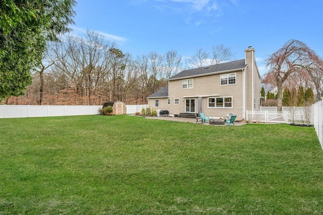 6 Premier Ct, Port Jefferson Station, NY 11776 - rear view of house featuring a fenced backyard, a lawn, a patio, a storage unit, and a chimney