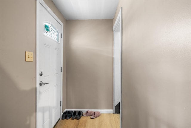 foyer featuring baseboards and wood finished floors