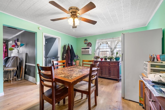 dining area featuring ornamental molding, ceiling fan, light wood finished floors, and a wall unit AC
