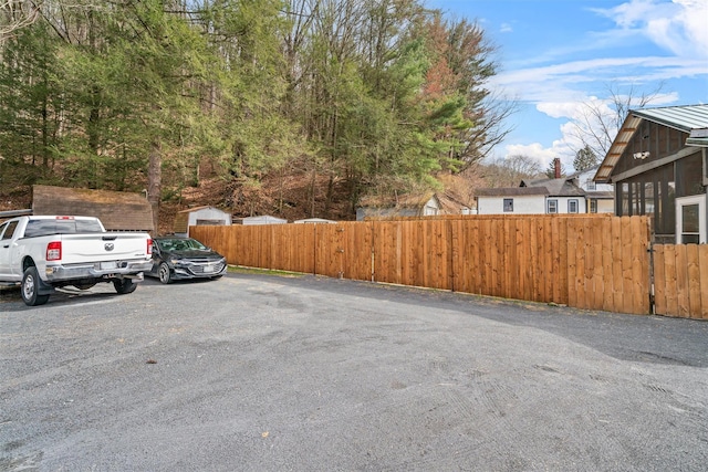 view of vehicle parking with fence