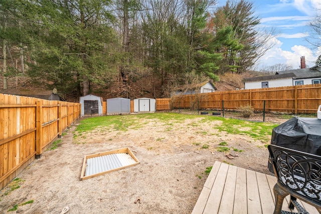 view of yard with an outbuilding, a fenced backyard, and a shed