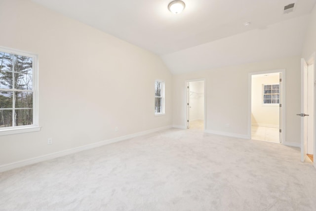 unfurnished bedroom with baseboards, light carpet, and multiple windows