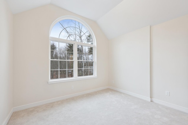 spare room with baseboards, carpet flooring, and vaulted ceiling