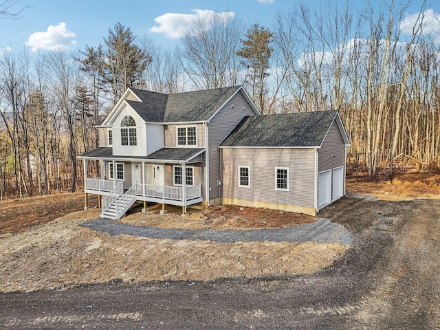 view of front of property with aphalt driveway, roof with shingles, a porch, and an attached garage