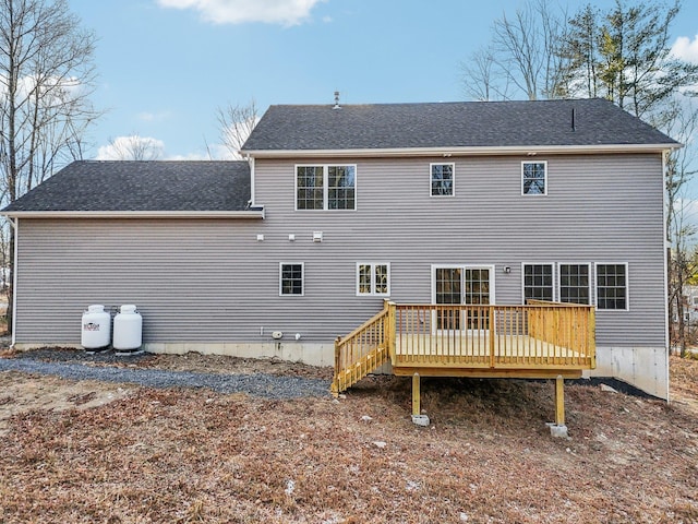rear view of house featuring a shingled roof and a wooden deck