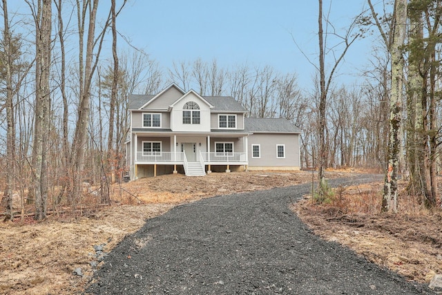 traditional-style home featuring gravel driveway and covered porch