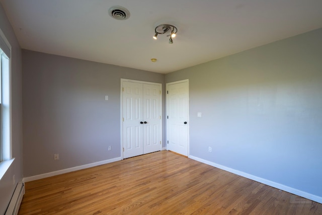 107 Denniston Dr, New Windsor, NY 12553 - unfurnished bedroom with baseboard heating, baseboards, wood finished floors, and a closet