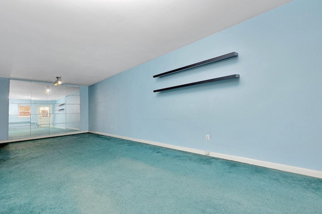 carpeted spare room featuring baseboards