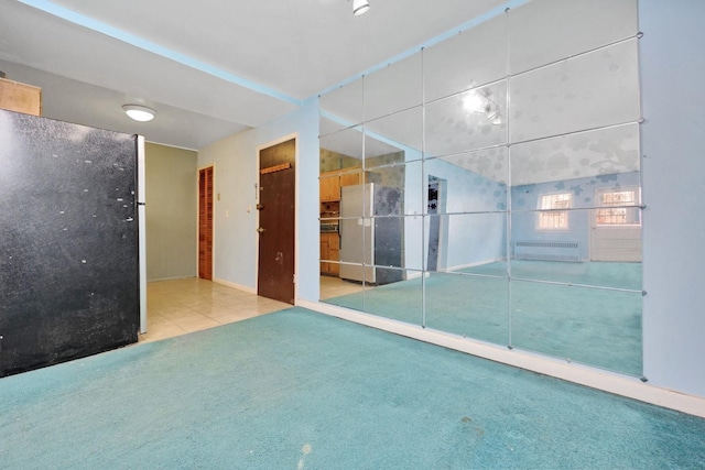empty room with tile patterned floors and carpet