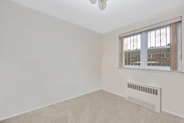 unfurnished room featuring carpet, baseboards, and radiator