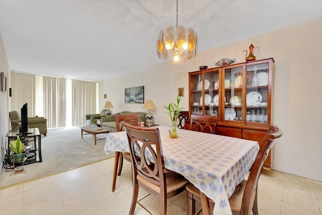 dining room featuring light colored carpet and a notable chandelier