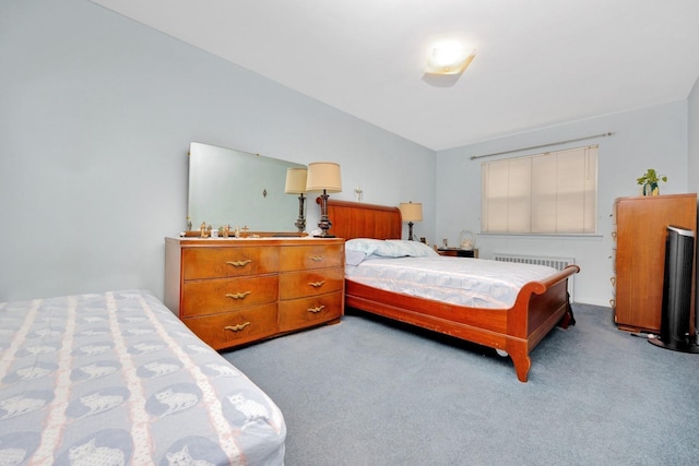 carpeted bedroom with radiator and lofted ceiling