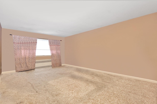 empty room with carpet, baseboards, and radiator