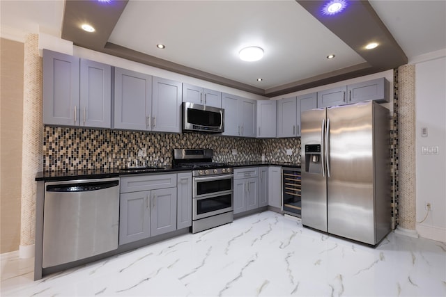 168 Vails Gate Heights Dr, New Windsor, NY 12553 - kitchen with stainless steel appliances, a tray ceiling, tasteful backsplash, gray cabinetry, and beverage cooler