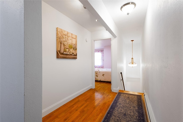 168 Vails Gate Heights Dr, New Windsor, NY 12553 - hall with light wood finished floors, baseboard heating, baseboards, and an upstairs landing