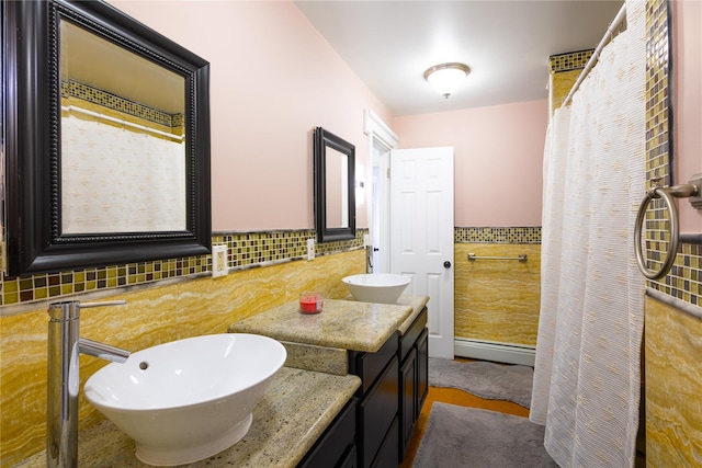 168 Vails Gate Heights Dr, New Windsor, NY 12553 - full bathroom featuring baseboard heating, a sink, double vanity, and tile walls