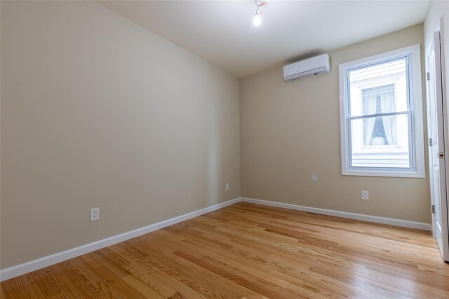 5933 48th Ave, Woodside, NY 11377 - unfurnished room with light wood-style flooring, a wall unit AC, and baseboards