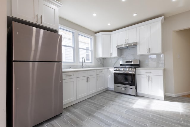 5933 48th Ave, Woodside, NY 11377 - kitchen featuring a sink, light countertops, under cabinet range hood, white cabinetry, and stainless steel appliances