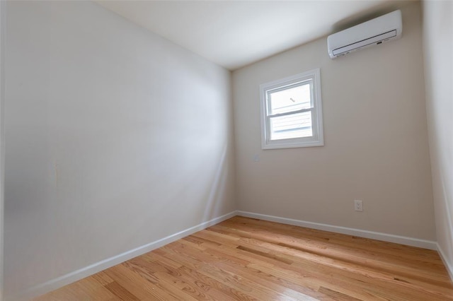 5933 48th Ave, Woodside, NY 11377 - spare room featuring light wood-style flooring, baseboards, and an AC wall unit