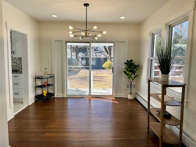 unfurnished dining area featuring a notable chandelier, baseboards, recessed lighting, visible vents, and dark wood finished floors