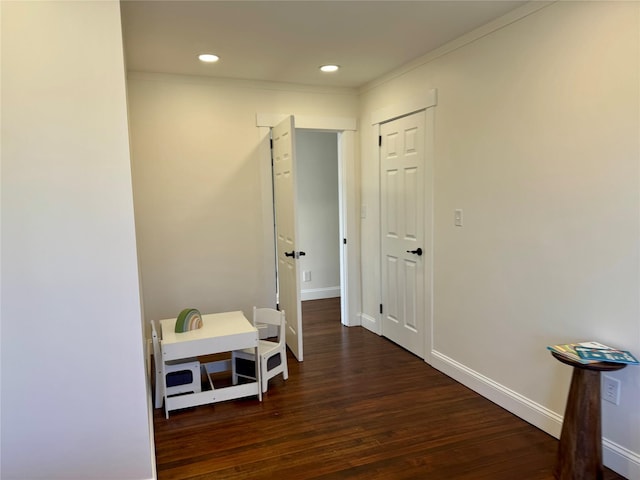 hall with crown molding, wood finished floors, baseboards, and recessed lighting
