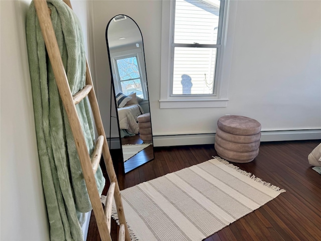 interior space with a baseboard radiator, wood finished floors, and a baseboard heating unit