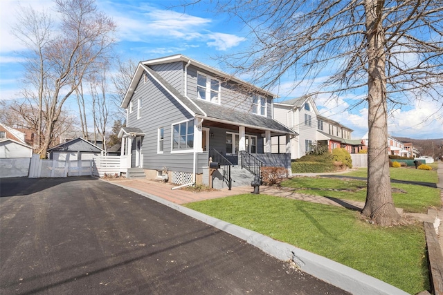 view of front of property featuring entry steps, roof with shingles, fence, a front lawn, and a garage