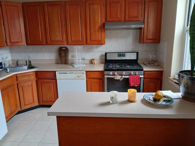kitchen featuring white dishwasher, a sink, light countertops, under cabinet range hood, and gas stove