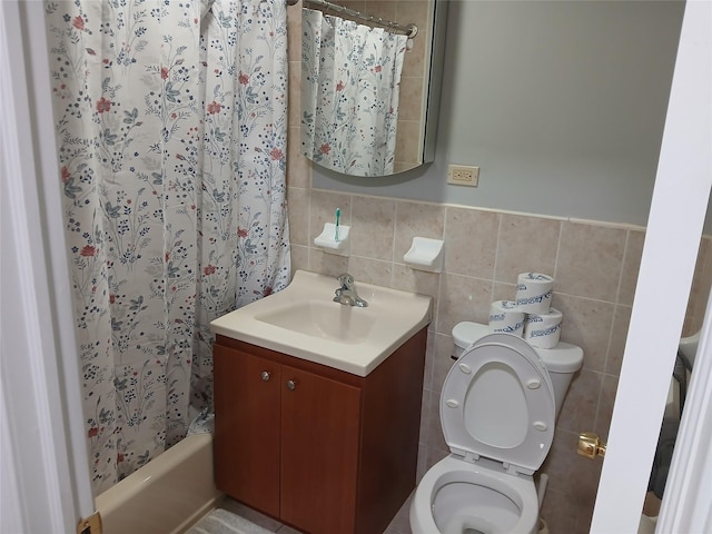 full bath with vanity, a wainscoted wall, toilet, shower / tub combo with curtain, and tile walls