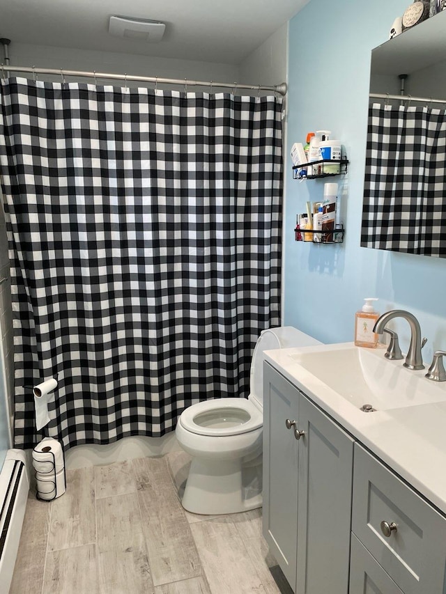 bathroom with toilet, a baseboard radiator, a shower with curtain, and vanity
