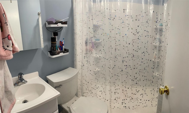 bathroom featuring toilet, curtained shower, and a sink