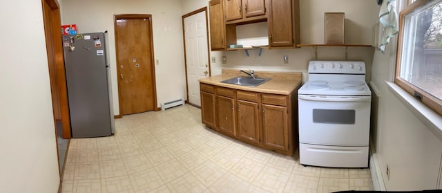 kitchen featuring open shelves, a baseboard heating unit, a sink, freestanding refrigerator, and electric range