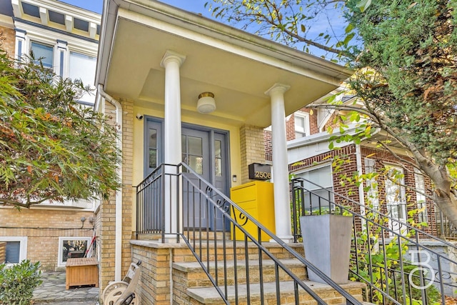 view of exterior entry featuring brick siding