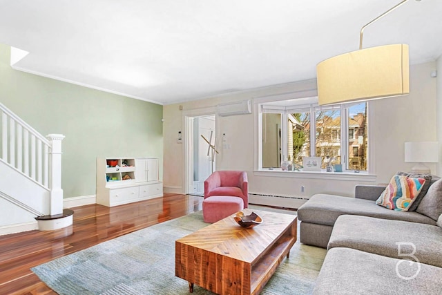 living room with crown molding, stairs, an AC wall unit, wood finished floors, and a baseboard radiator