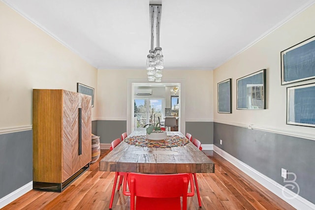 dining room with baseboards, wood finished floors, and crown molding
