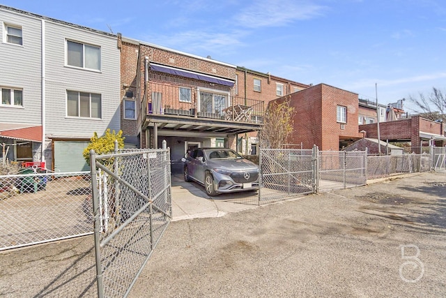 view of property featuring a gate, fence, a residential view, and driveway