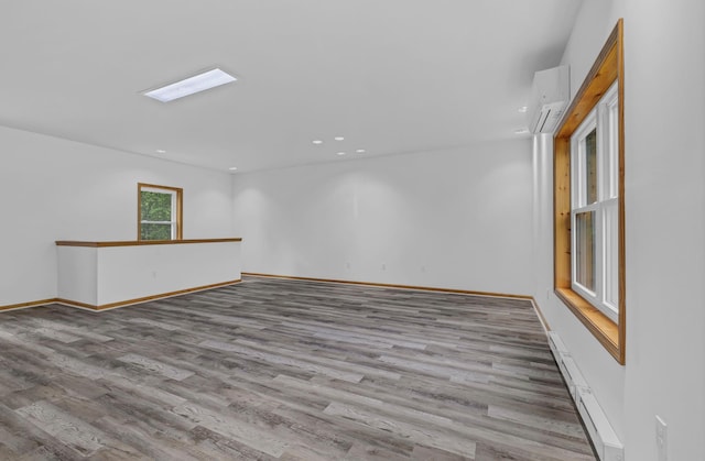 309 Quannacut Rd, Pine Bush, NY 12566 - empty room featuring wood finished floors, a wall mounted air conditioner, recessed lighting, baseboards, and a baseboard radiator