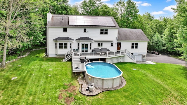 309 Quannacut Rd, Pine Bush, NY 12566 - rear view of house featuring stairway, a wooden deck, roof mounted solar panels, an outdoor pool, and a shingled roof