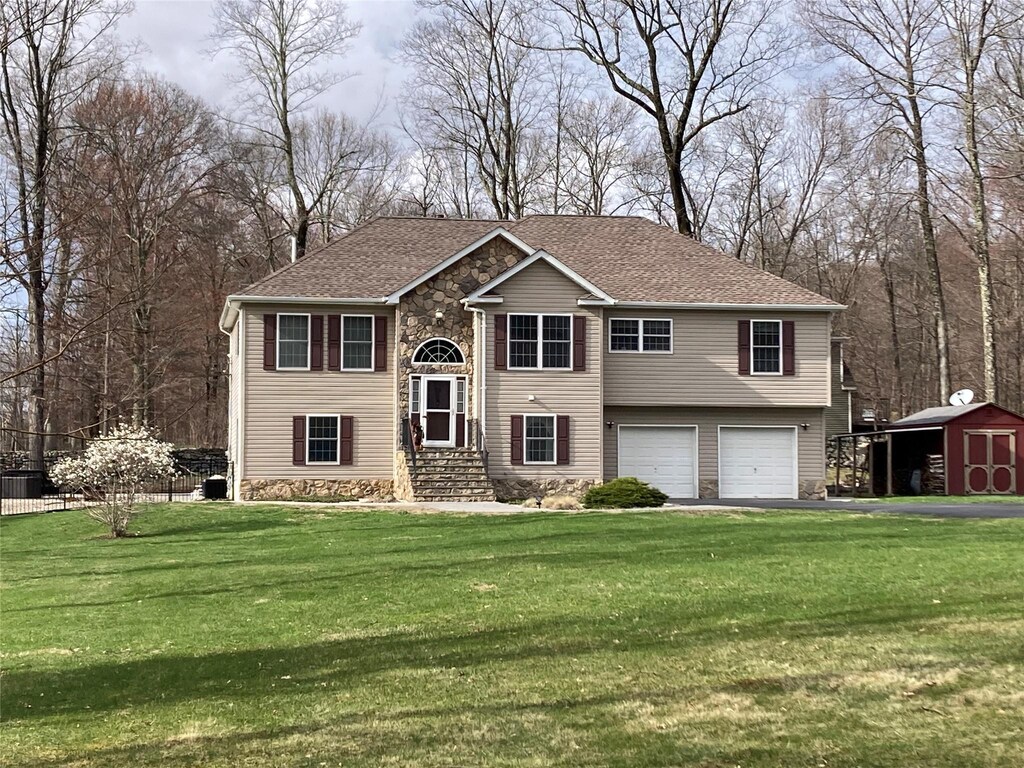 223 Rabbit Run Rd, Clintondale, NY 12515 - split foyer home with stone siding, a garage, aphalt driveway, an outdoor structure, and a front lawn