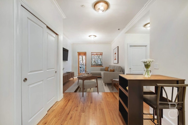 hall featuring light wood finished floors and crown molding