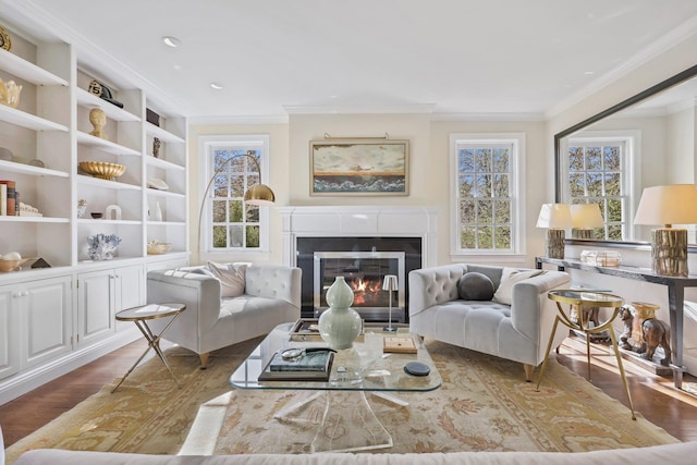 sitting room featuring recessed lighting, a glass covered fireplace, ornamental molding, and wood finished floors