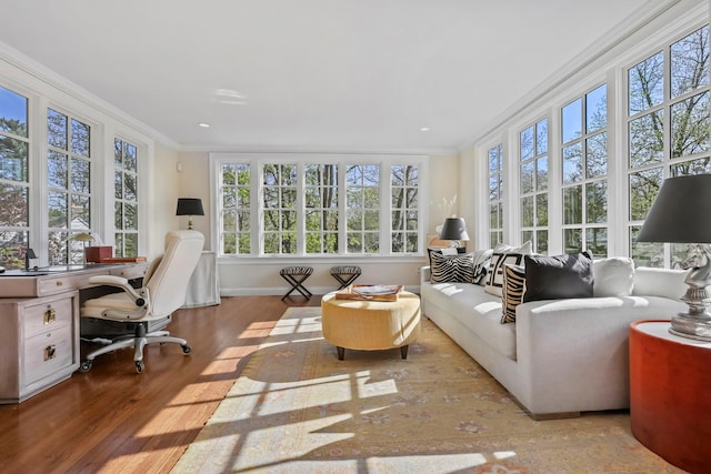 sunroom / solarium with crown molding, plenty of natural light, and wood finished floors