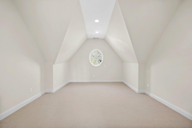 additional living space featuring baseboards, recessed lighting, vaulted ceiling, and light carpet