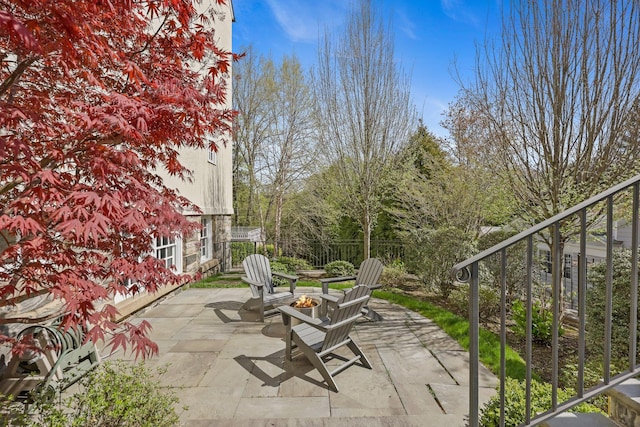 view of patio featuring fence and a fire pit