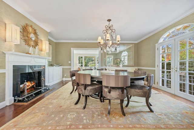 dining room with french doors, crown molding, wood finished floors, and a chandelier