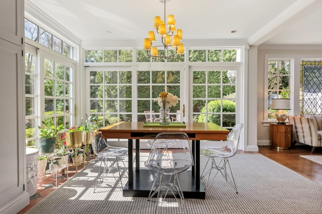 sunroom / solarium with baseboards, a chandelier, ornamental molding, and a wealth of natural light