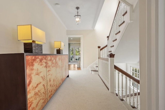 corridor featuring ornamental molding, carpet flooring, and stairway