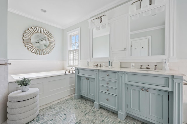 bathroom with double vanity, a bath, crown molding, wainscoting, and a decorative wall